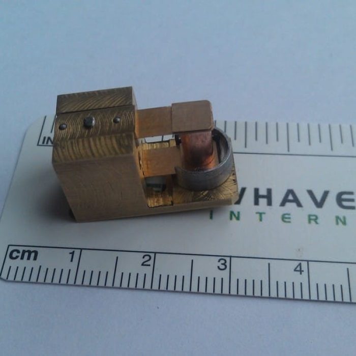 Assembled 1D resonant actuator prototype for a portable OCT system shown against a metric scale